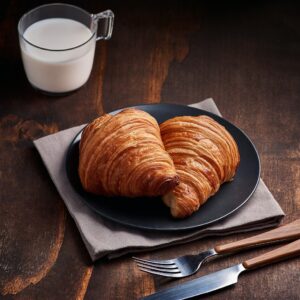 bread on brown wooden tray beside white ceramic mug