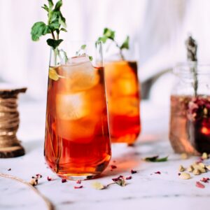 red liquid with ice and plant