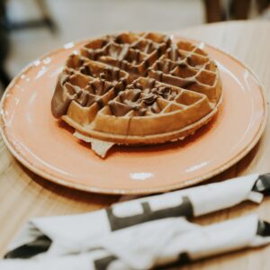 waffle on pink ceramic plate placed on wooden table