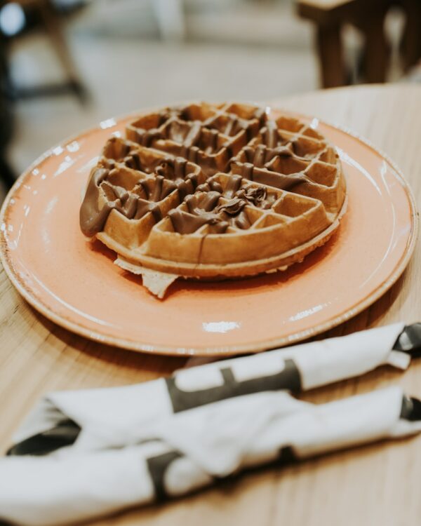 waffle on pink ceramic plate placed on wooden table